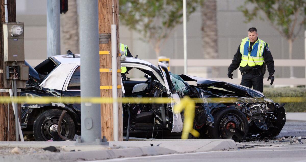 Ontario police officers look over the smashed vehicle which broadsided a San Bernardino Police Department squad car, killing officer Bryce Hanes early Thursday morning, Nov. 5, 2015, in Ontario, Calif.