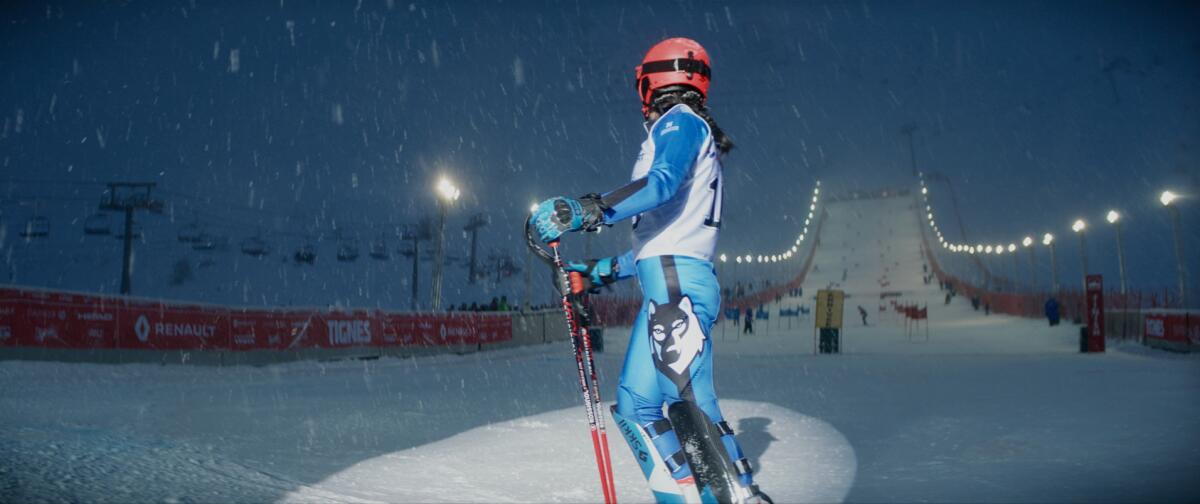 A woman at the bottom of a ski run.