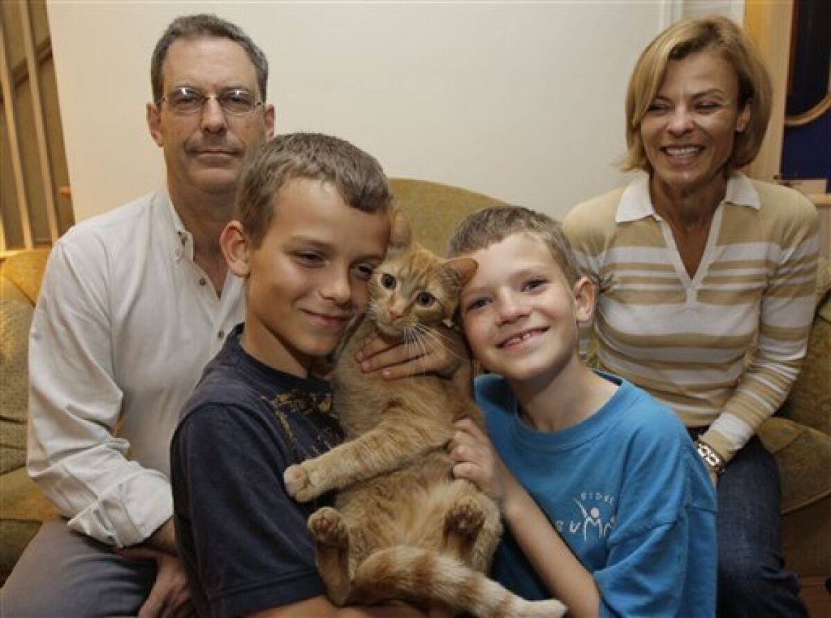 Leo Lytel, second from right, 9, and his family David Lytel, left, Lucas Lytel, 11, and Jayne Lytel pose for a photograph with one of the family cats in their home in Washington Wednesday, May 6, 2009. Leo was diagnosed with autism as a toddler. He was undiagnosed at age 9. Provocative new research suggests that 10 percent of autistic children actually "recover" from the troubling developmental disorder and lose the diagnosis later on in childhood. (AP Photo/Alex Brandon)