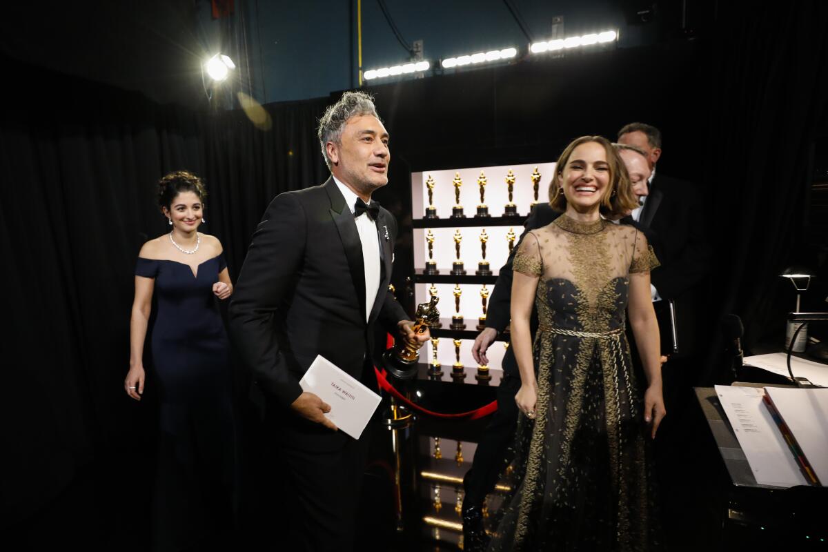 Taika Waititi, winner of the adapted screenplay Oscar for “Jojo Rabbit,” with presenter Natalie Portman