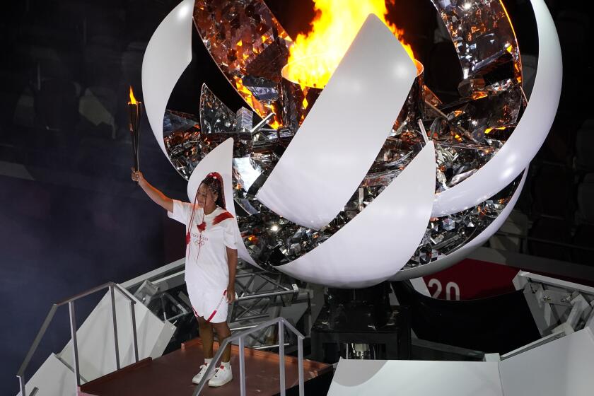 Naomi Osaka lights the Olympic cauldron during the opening ceremony at the Olympic Stadium at the 2020 Summer Olympics, Friday, July 23, 2021, in Tokyo. (AP Photo/Morry Gash)