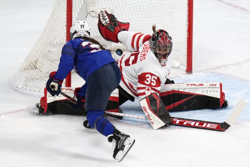 Canada goalkeeper Ann-Renee Desbiens (35) blocks a shot by United States' Abbey Murphy (37) during a preliminary round women's hockey game at the 2022 Winter Olympics, Tuesday, Feb. 8, 2022, in Beijing. (AP Photo/Petr David Josek)