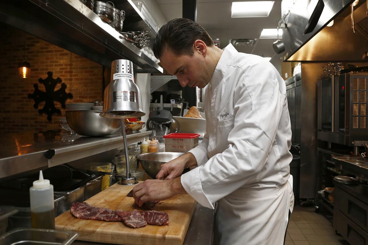 Chef and owner Jeoffrey Offer cuts a skirt steak at Butcher's House, a modern brasserie, at SoCo Collection in Costa Mesa.