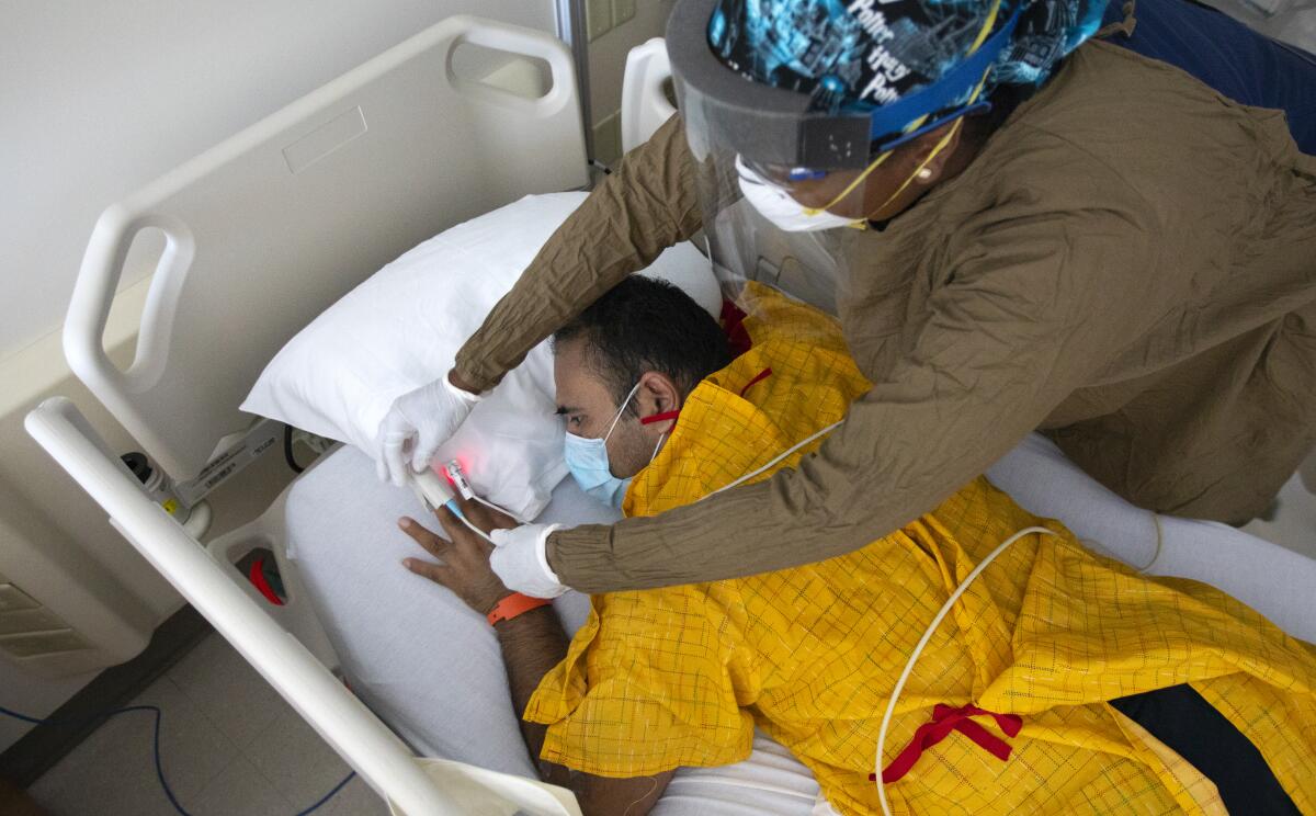 Nurse works with patient at Martin Luther King Jr. Community Hospital