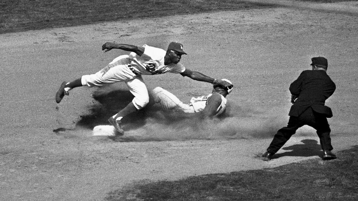 Dodger's Jim Gilliam makes a tag as Cincinnati Reds' Tommy Harper slides safely into second during the sixth inning.