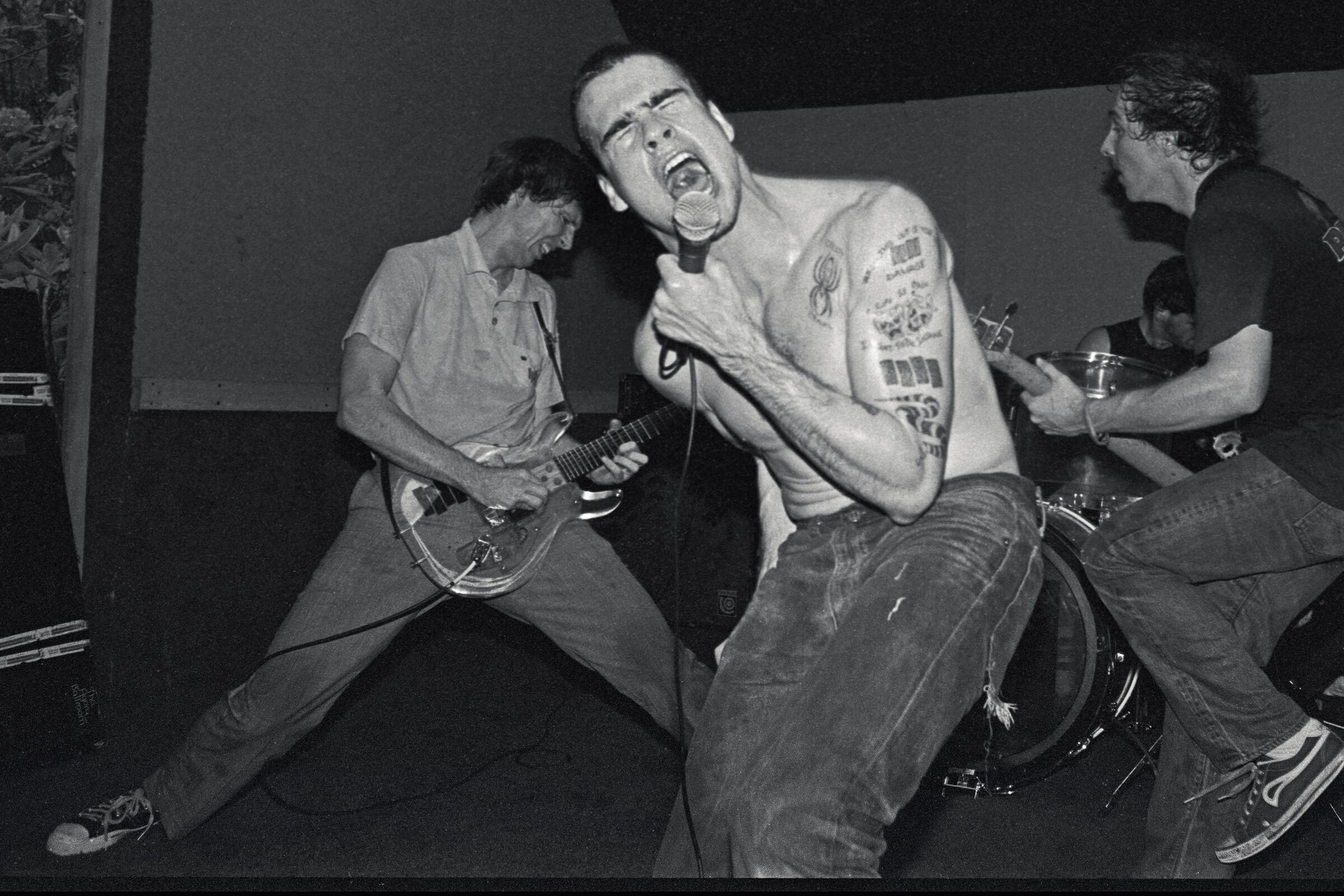 Greg Ginn and Black Flag's Chuck Dukowski jam on guitars while Henry Rollins lets out a yell.