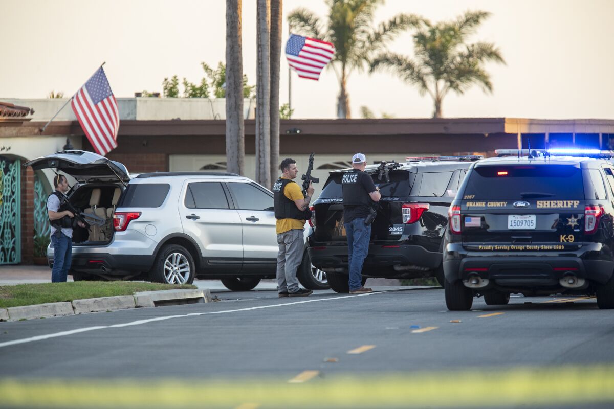 Police officers stage on Santiago Drive in Newport Beach.
