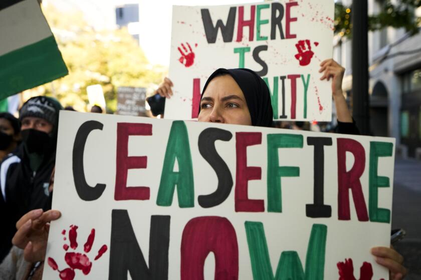 A woman holds a "Ceasefire Now," sign during a pro-Palestinian rally and march, Saturday, Oct. 28, 2023, in Seattle. (AP Photo/Lindsey Wasson)