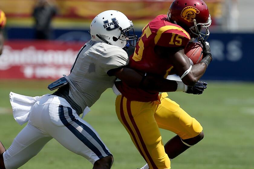 USC receiver Nelson Agholor makes a catch against Utah State cornerback Nevin Lawson in the first half Saturday at the Coliseum.
