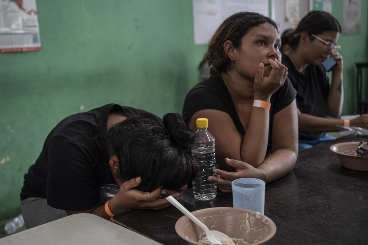 Yeneska García, inmigrante venezolana, llora con la cabeza entre las manos mientras come