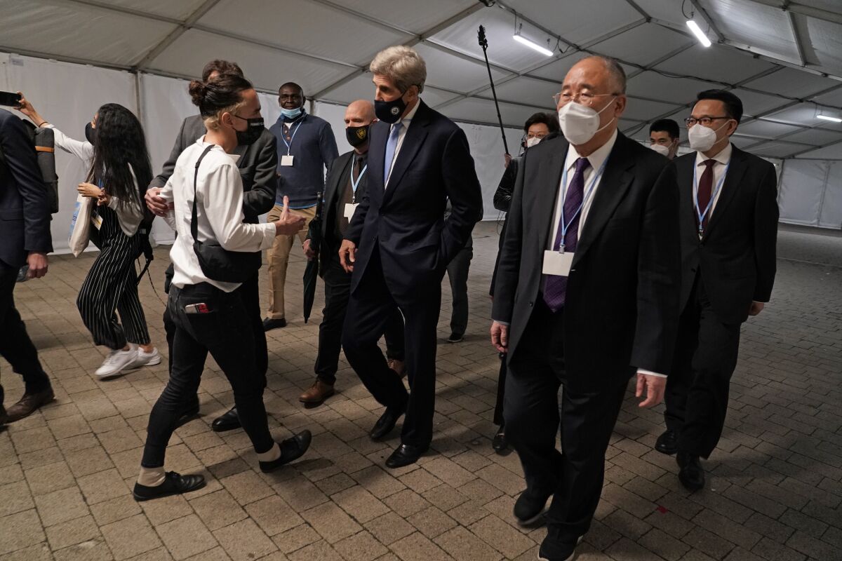 China's chief negotiator Xie Zhenhua, right, walks with John Kerry, United States Special Presidential Envoy for Climate at the COP26 U.N. Climate Summit in Glasgow, Scotland, Friday, Nov. 12, 2021. Going into overtime, negotiators at U.N. climate talks in Glasgow are still trying to find common ground on phasing out coal, when nations need to update their emission-cutting pledges and, especially, on money. (AP Photo/Alberto Pezzali)