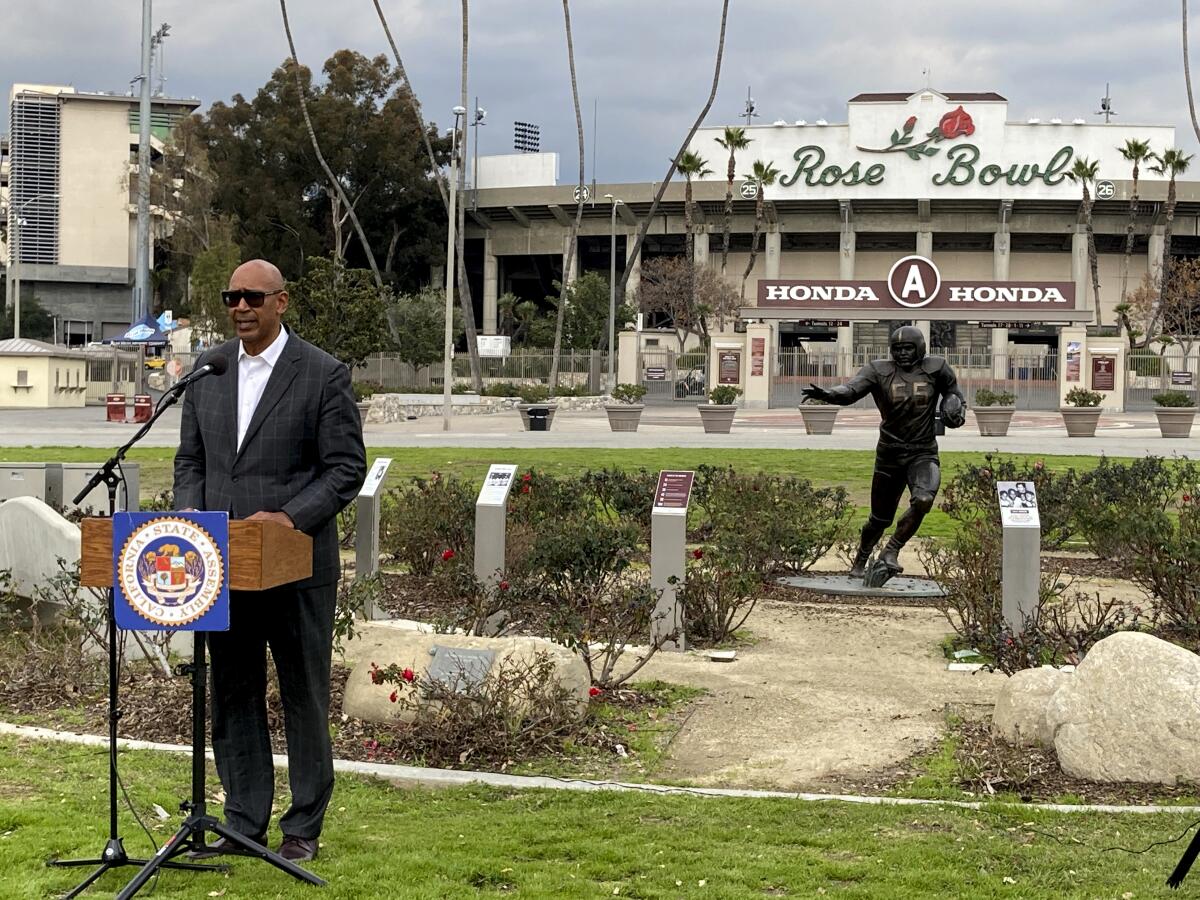 California Assemblymember Chris Holden discusses a bill called the College Athlete Protection Act in front of the Rose Bowl on Thursday, Jan. 19, 2023, in Pasadena, Calif. The bill would require schools that play major college sports to pay some athletes as much as $25,000 annually, along with covering the cost of six-year guaranteed athletic scholarships and post-college medical expenses. (AP Photo/Beth Harris)