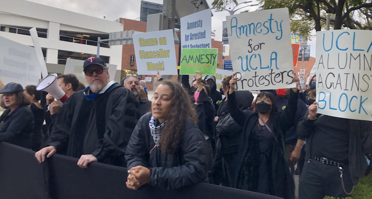 About 20 people hold signs with messages such as "Amnesty for UCLA protesters" and "Shame on Chancellor Block."