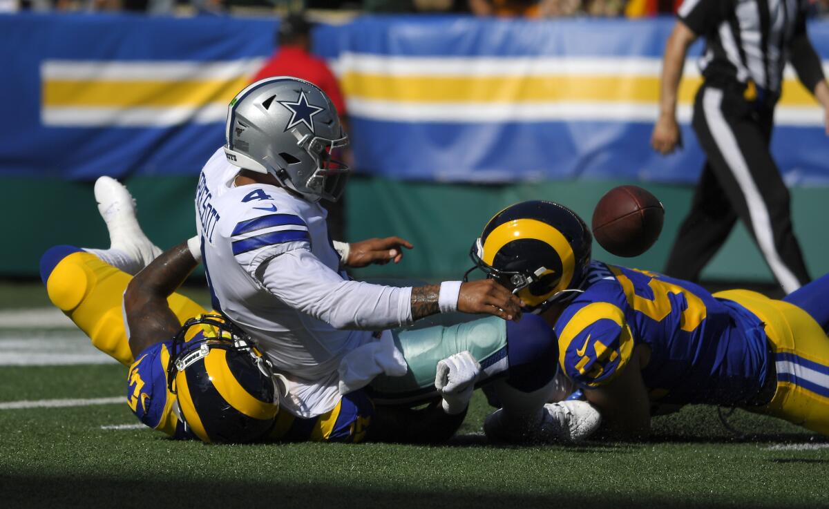 Rams linebackers  Natrez Patrick, left, and Bryce Hager sack Cowboys quarterback Dak Prescott.