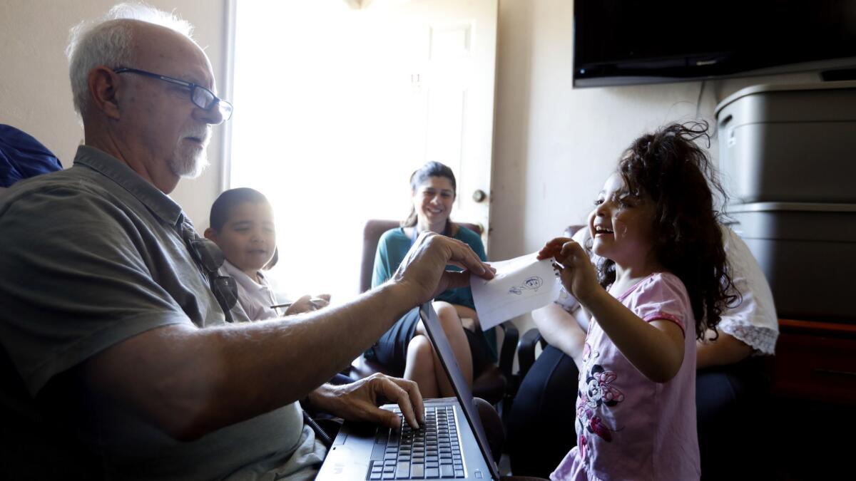 Times columnist Steve Lopez shares paper and pens with Sophia, 4, right, while interviewing her family living in a motel in Pacoima.