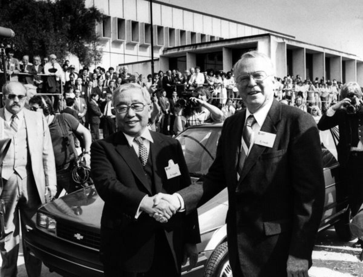 FILE - In this April 13, 1985 file photo, Toyota Motor Corp. Chairman Eiji Toyoda, left, and General Motors Corp. Chairman Roger B. Smith shake hands in front of a Chevrolet Nova as the new United Motor Manufacturing Inc., a $400 million joint venture between GM and Toyota, was inaugurated with a dedication ceremony at the Fremont, Calif., plant. (AP photo/Paul Sakuma, File)