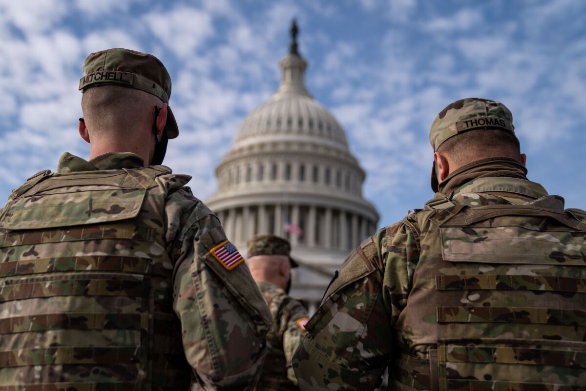 Members of the National Guard in the plaza in front of the U.S. Capitol building.