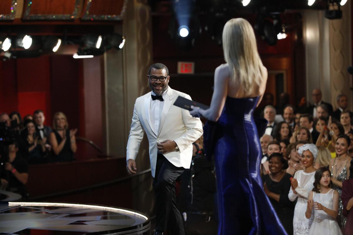 Jordan Peele walks up to accept his Oscar for original screenplay at the 90th Academy Awards.