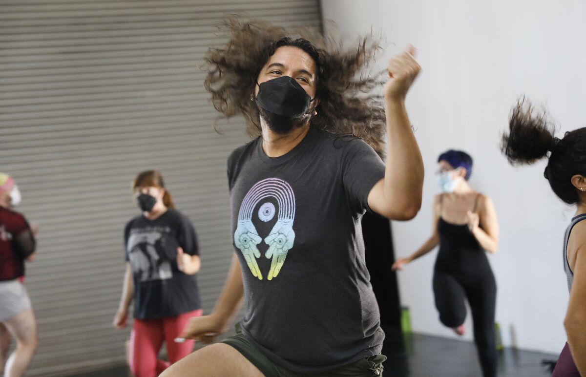  A person with long hair flying does aerobic dance moves. 