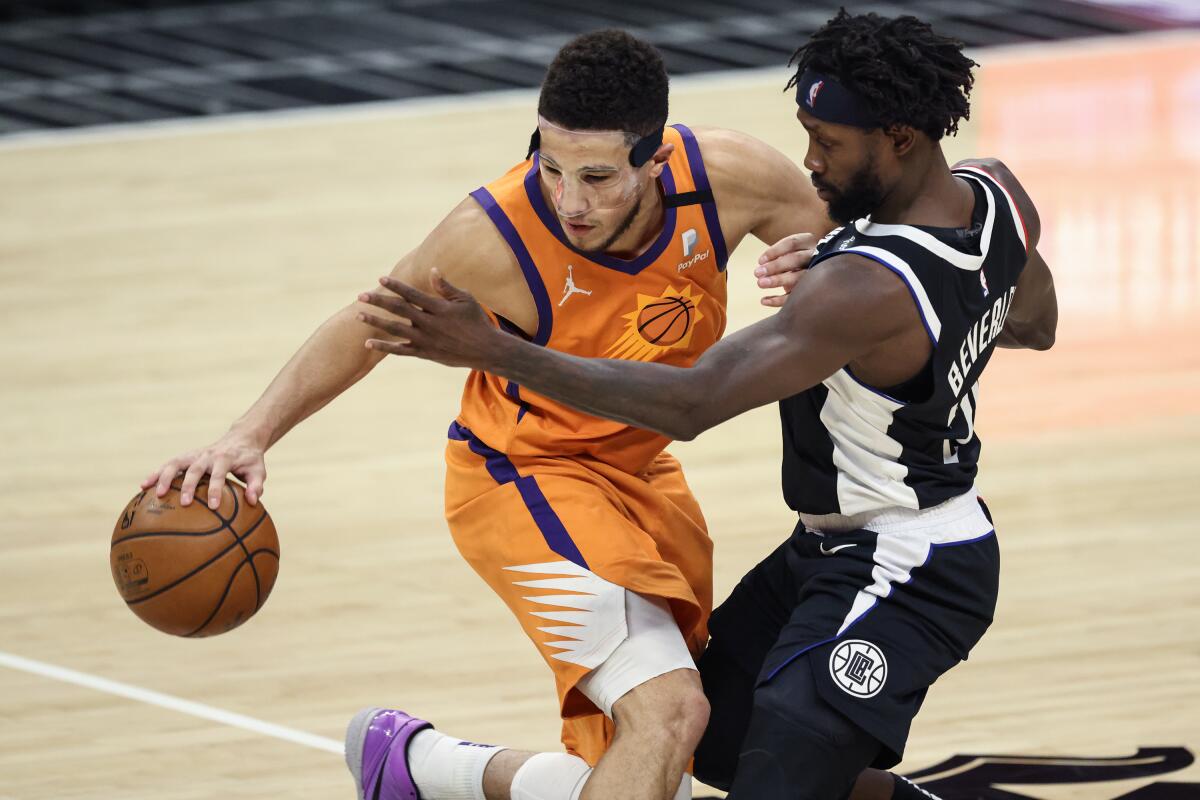 Clipper guard Patrick Beverley disrupts the dribble of Suns guard Devin Booker.