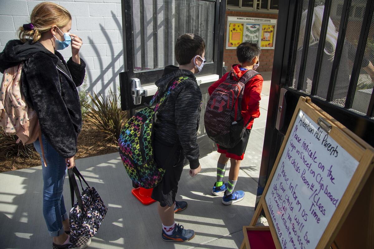 Students wait outside the gate at Agnes L. Smith Elementary School on the first day of in-person learning.