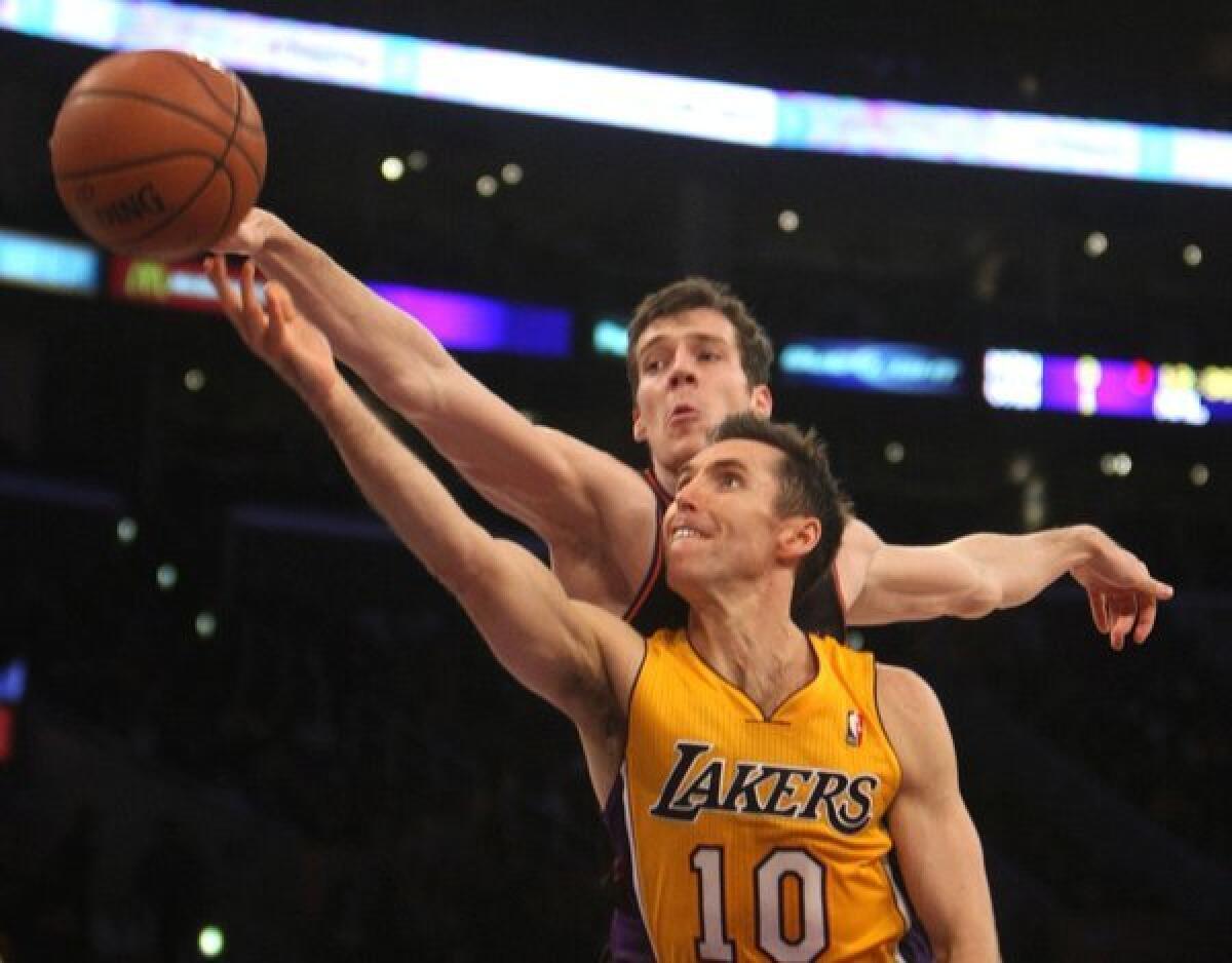 Lakers point guard Steve Nash lays it in as Phoenix guard Goran Dragic applies pressure during a game on Feb. 12.