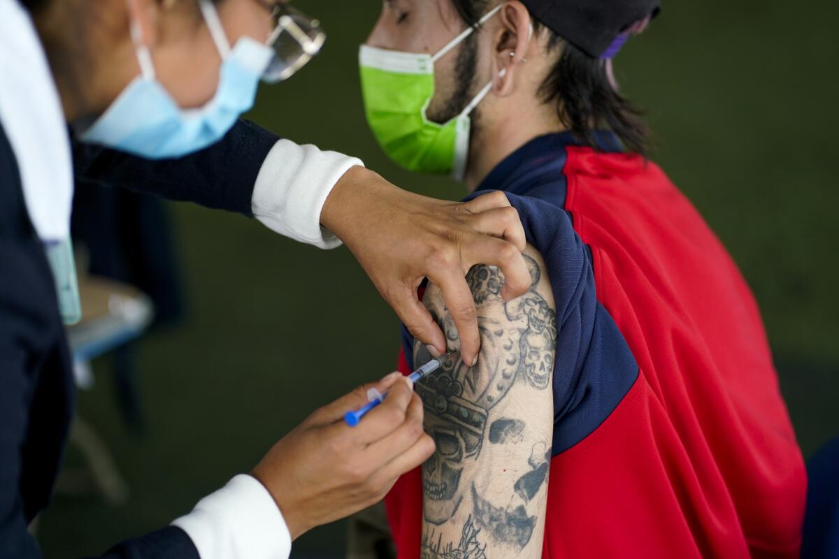 A healthcare worker injects a person with a dose of the Pfizer COVID-19, during a vaccination drive for people between the ages of 18-29, in Mexico City, Thursday, Aug. 19, 2021. (AP Photo/Eduardo Verdugo)