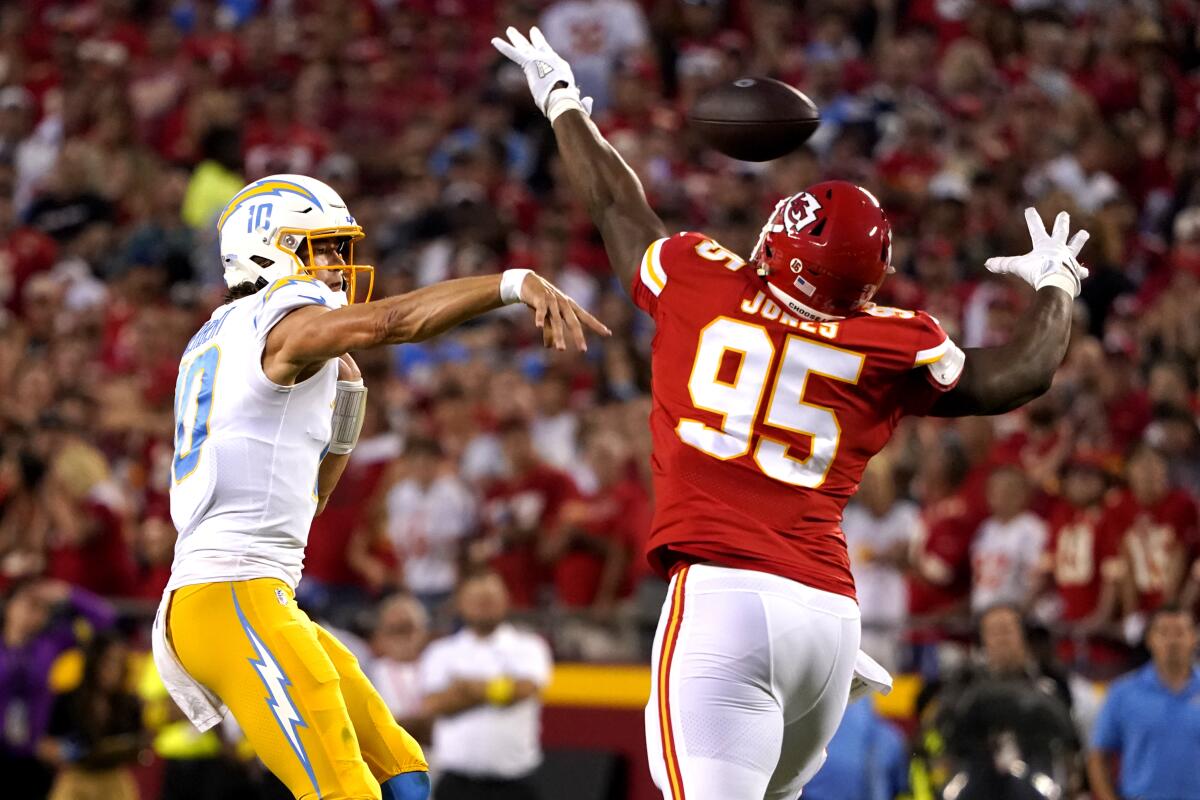 Chargers quarterback Justin Herbert passes as Kansas City Chiefs defensive tackle Chris Jones (95) pursues.