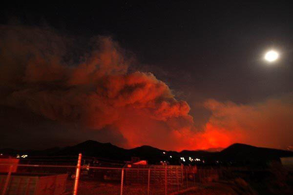 Smoke from the Station fire billows as the moon glows over Soledad Canyon Road in Acton.