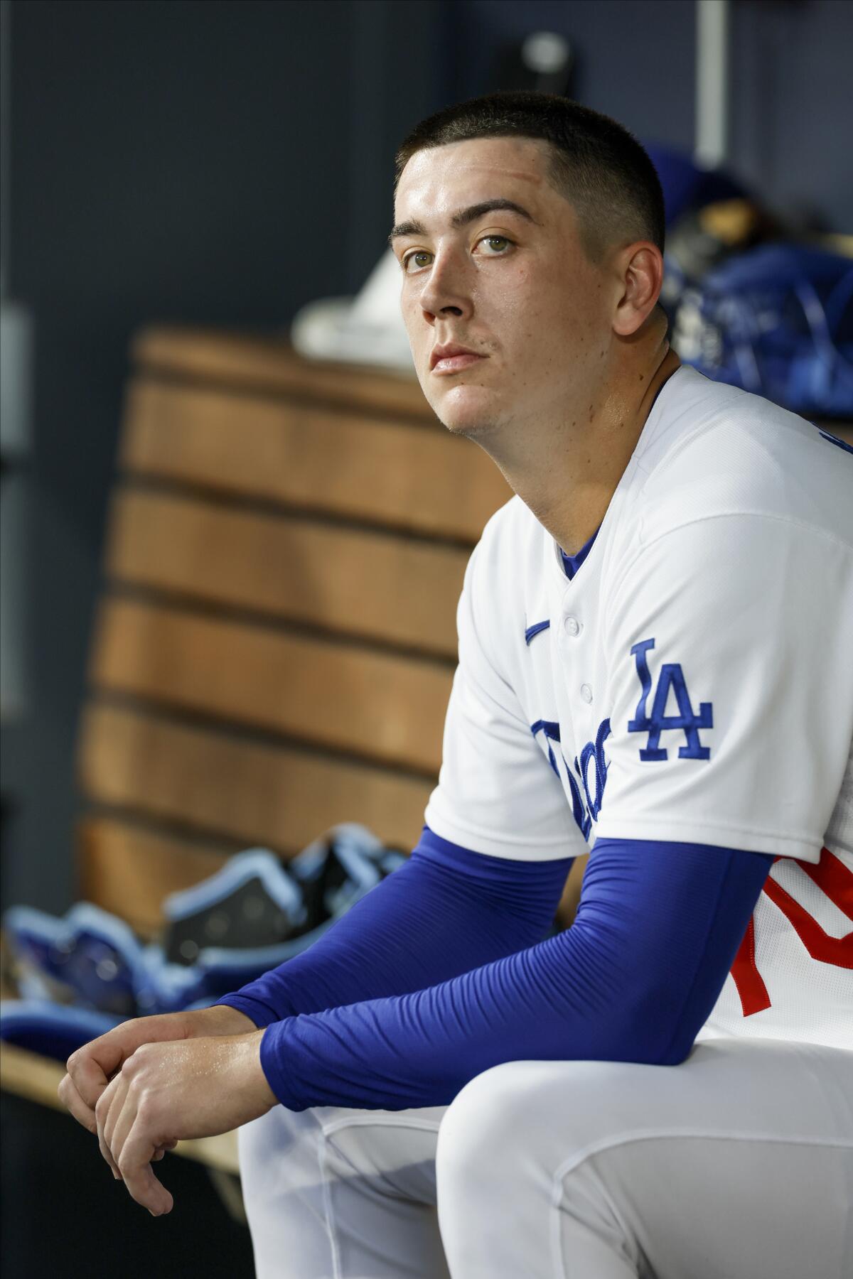 Dodgers starting pitcher Bobby Miller sits in the dugout after the first inning of Game 2.