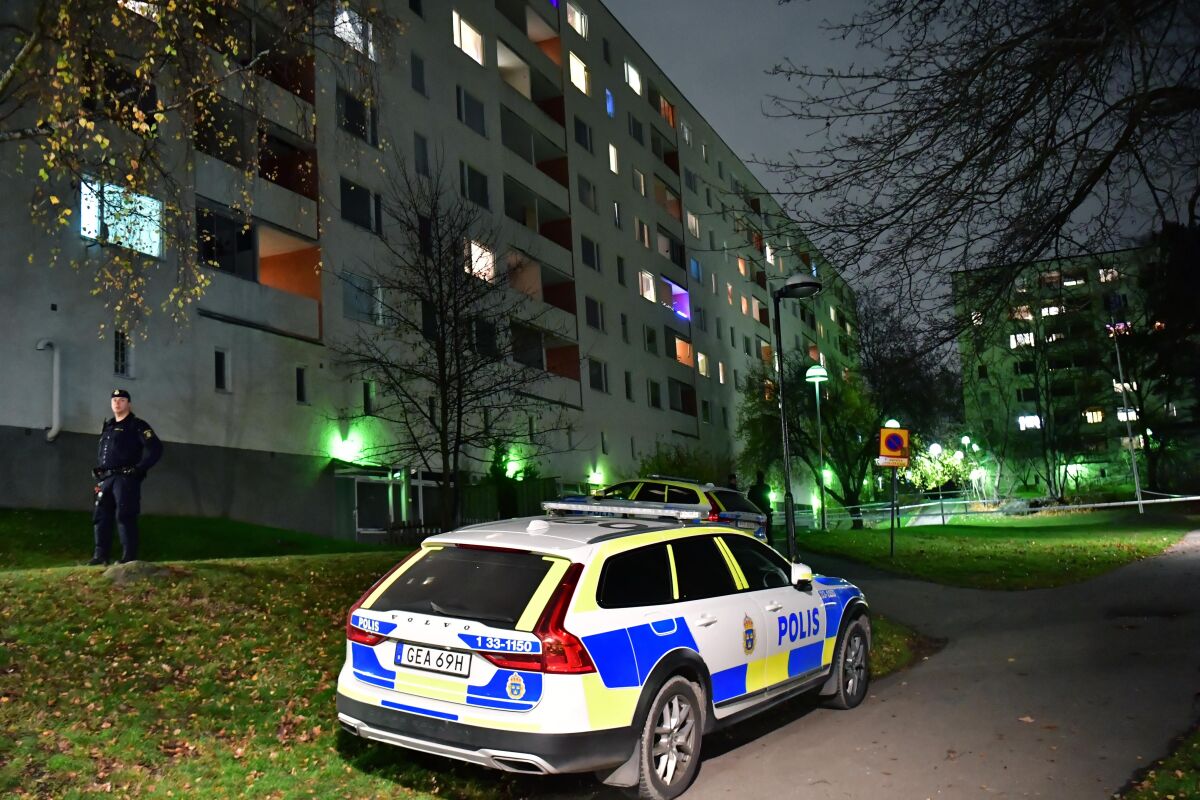 Police outside an apartment block after an incident, in Hasselby, northwest Stockholm, Sunday, Nov. 14, 2021. Swedish police say they have arrested two adults on suspicion of murder after two children fell from “a great height” and one of them died. Those arrested are a man and a woman, police said. The children who were reportedly were siblings and both under the age of 10, were rushed to the hospital. (Jonas Ekstromer/TT News Agency via AP)