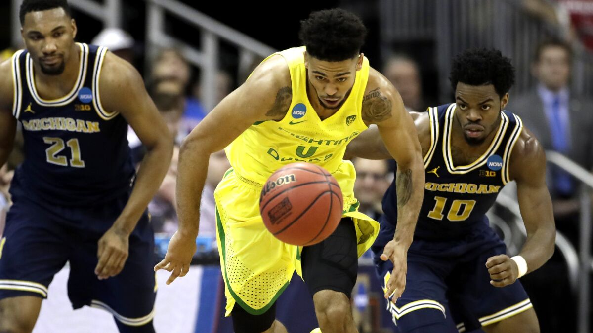 Oregon guard Tyler Dorsey comes up with a steal against Michigan's Zak Irvin (21) and Derrick Walton Jr. (10) during the second half Thursday night.