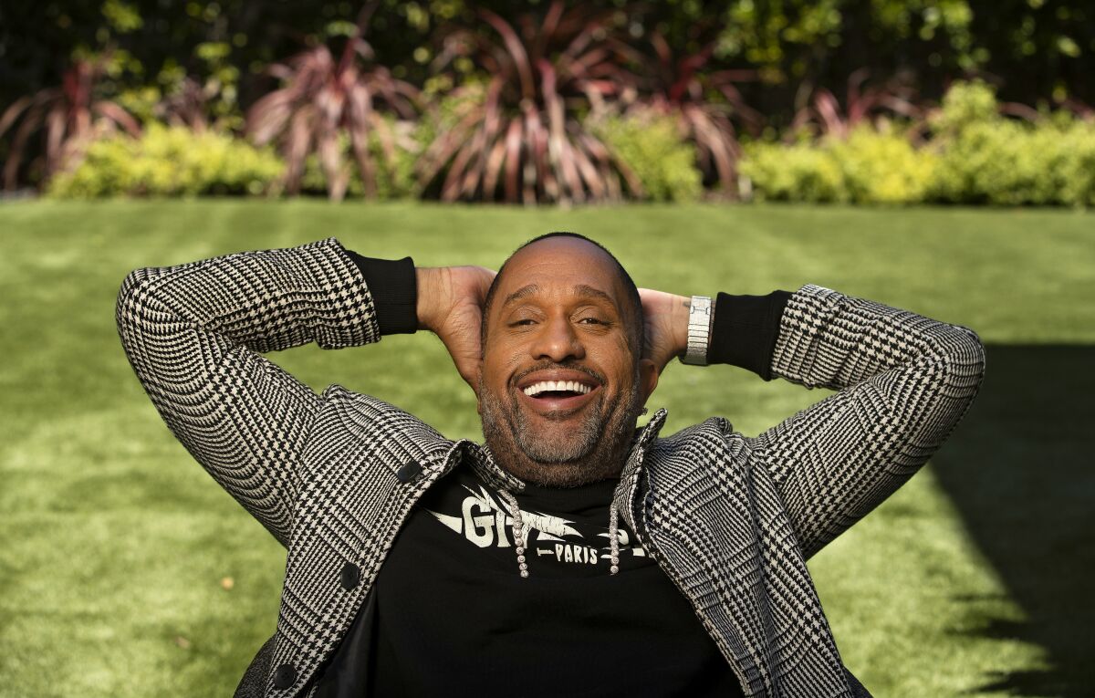 Kenya Barris sits on the lawn at his home in Encino with his hands behind his head.