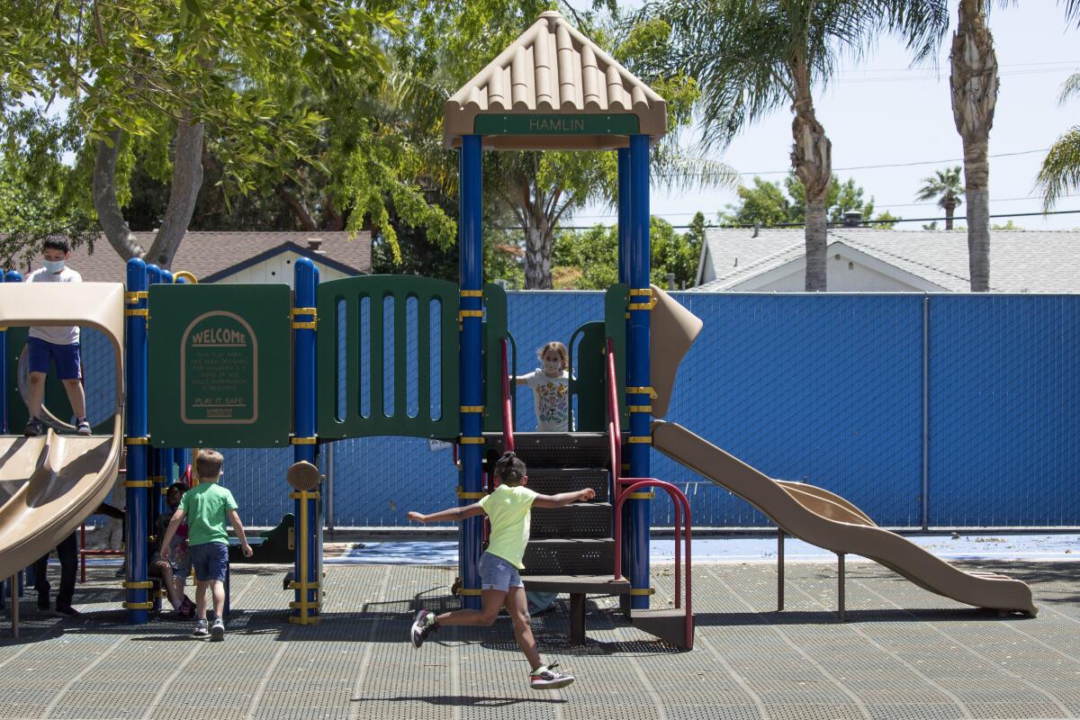 Children running and climbing at a playground. 