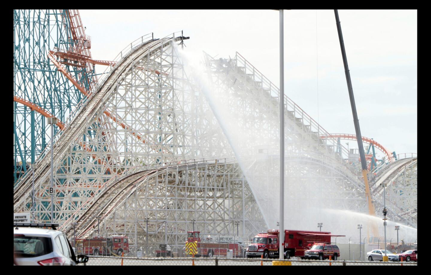 Firefighters battle a blaze that damaged the iconic Colossus roller coaster at Six Flags Magic Mountain.