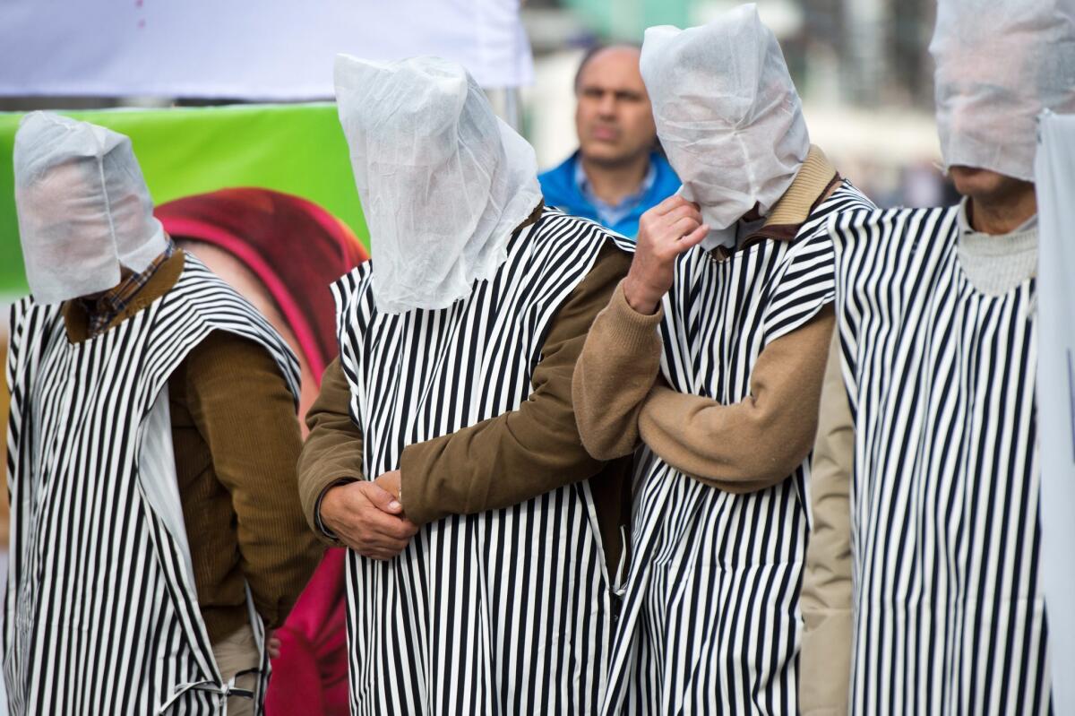 Exiled Iranians of the Iranian National Opposition in Germany, their heads covered, demonstrate against human rights violations in Iran, in particular against executions, across from the U.S. Embassy in Berlin on Saturday.