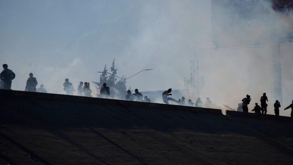 Migrants run from tear gas launched by U.S. agents at part of the border with Mexico in Tijuana on Nov. 25.