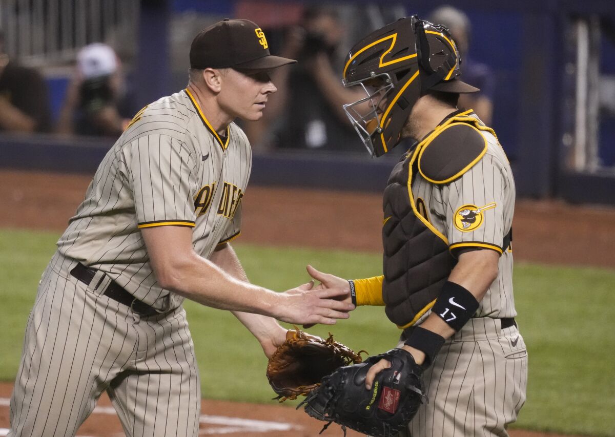 The Padres' Mark Melancon and Victor Caratini celebrate the win against the Miami Marlins on July 23, 2021 in Miami.