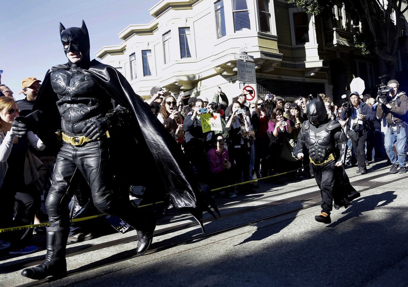 Miles Scott, dressed as Batkid, runs with Batman after saving a damsel in distress in San Francisco. The 5-year-old boy, whose leukemia was in remission, wsa participating in a Make-A-Wish Foundation event.