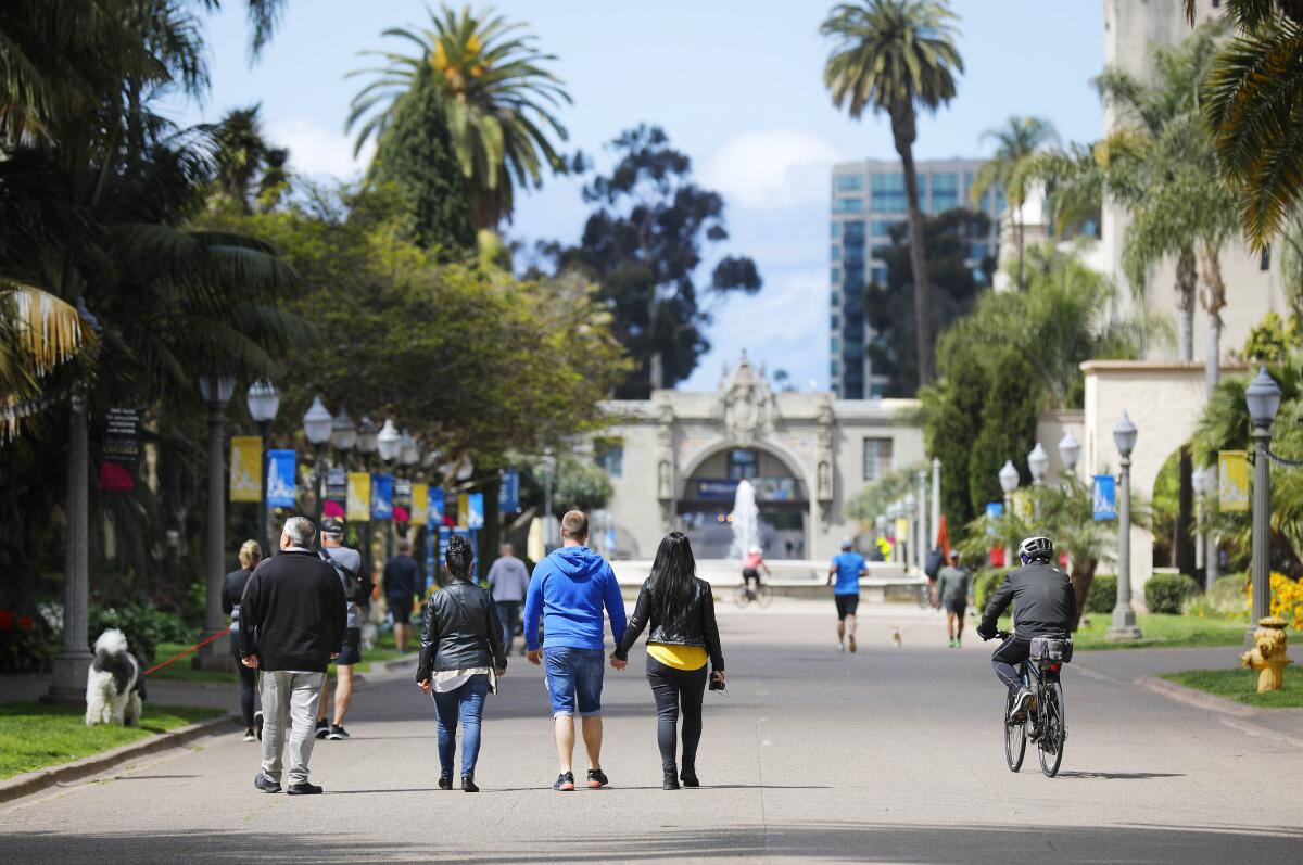 People walk and bike along El Prado at Balboa Park on March 24, 2020.