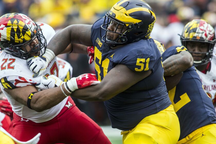 In this Oct. 6, 2018 photo, Michigan center Cesar Ruiz (51) blocks Maryland linebacker Isaiah Davis (22) during an NCAA college football game in Ann Arbor, Mich. When Ruiz left New Jersey to visit IMG Academy in Florida, his mother said he wasn't coming back home with her. Ruiz will be back in his home state this week when the fourth-ranked Wolverines play at Rutgers. (AP Photo/Tony Ding)