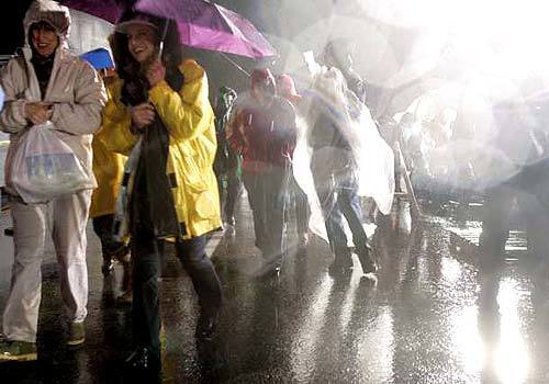 Before sunrise, parade goers braved the rain along the main route of the Tournament of Roses Parade. Many were anxious to see if the New Years storm would subside by showtime.