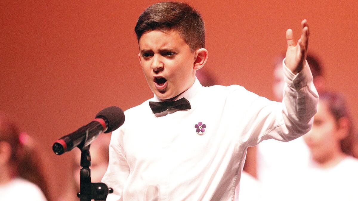 Eric Chilingaryan, 12, with the Davidian & Mariamian Education Foundation, recites a speech during the Armenian Genocide commemoration at the Alex Theatre in Glendale on Tuesday.