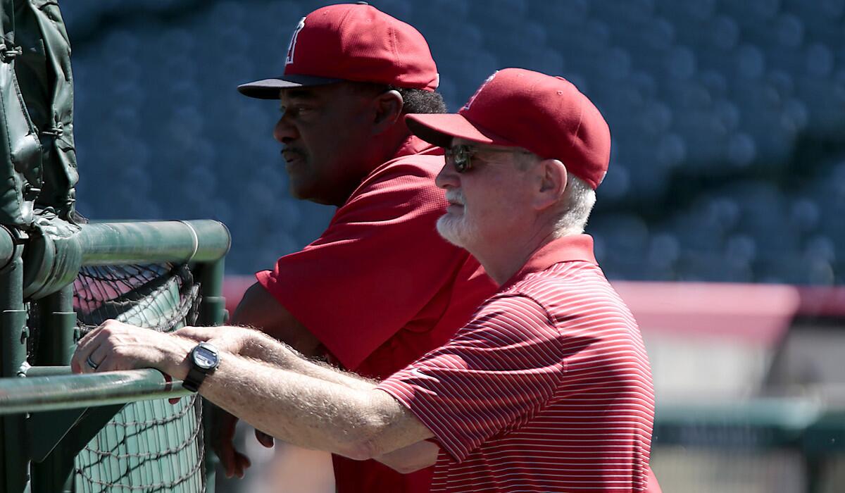 Angels trainer Rick Smith visits with hitting coach Don Baylor during an off-day workout at Angel Stadium.