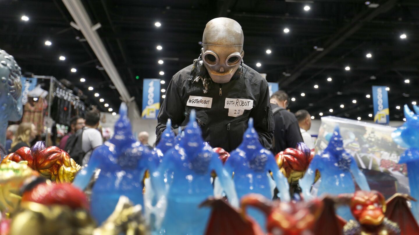 A man who goes by Goth Robot looks over creatures on display at the PopLife-Mind Style booth at Comic-Con International 2017.