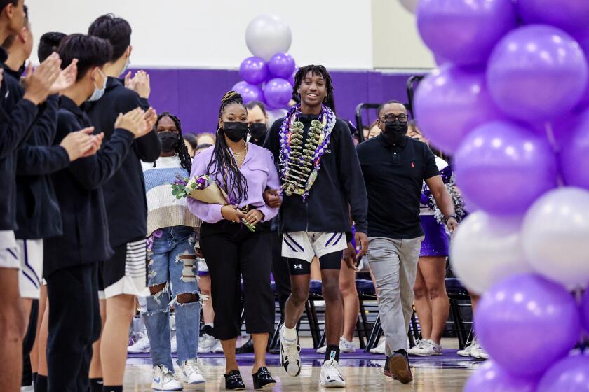 Irvine, CA, Friday, January 28, 2022 - Makai Brown, walks with his sister, Aubrey, far left, mother, Sabrina and father Terrell, right, during a senior celebration at Portola High School before a basketball game against Irvine High School on senior night. Makai and his family have spoken publicly in the last few days about racist comments that were directed at him during a game at Laguna Hills High School recently. (Robert Gauthier/Los Angeles Times)