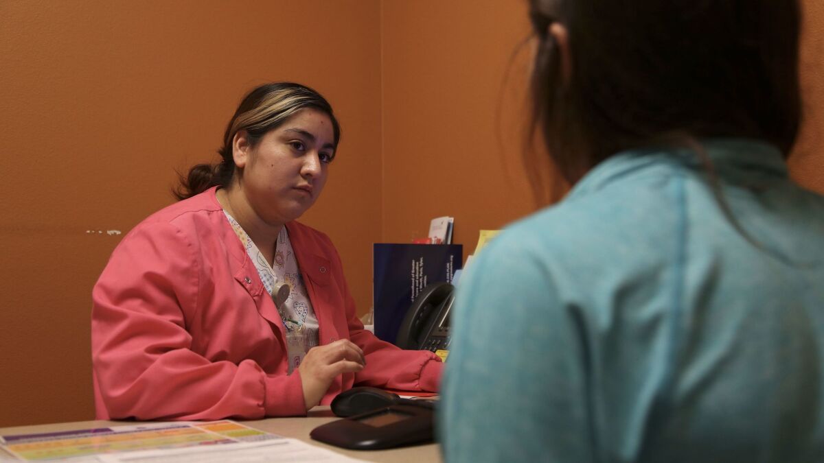 Lilibeth Juarez, a Planned Parenthood health center senior assistant, speaks with a patient about birth control in Fort Worth.