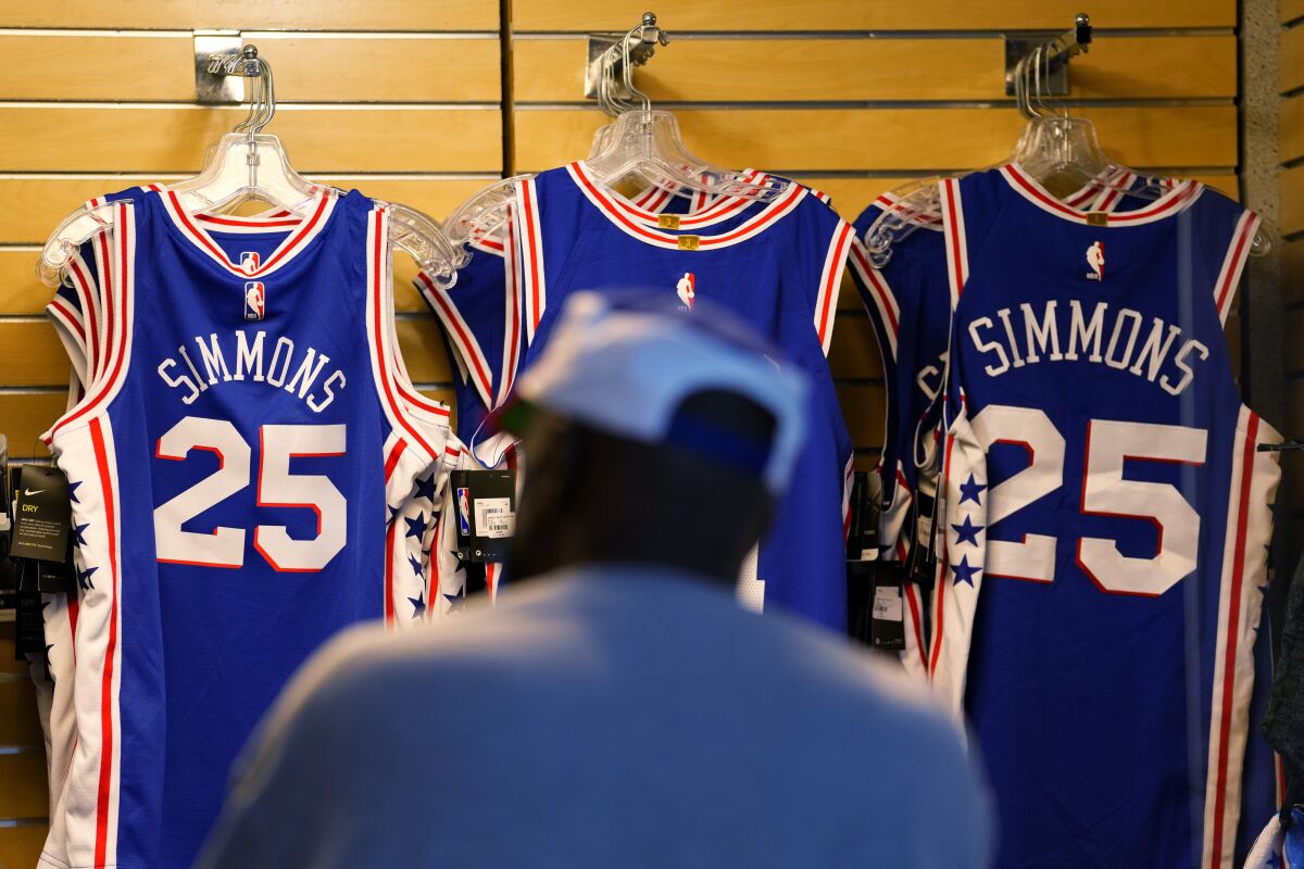 A fan shops for souvenirs before a preseason NBA basketball game between the Philadelphia 76ers and the Toronto Raptors, Thursday, Oct. 7, 2021, in Philadelphia. Ben Simmons was out of sight, out of mind and out of the team pregame hype video for the Philadelphia 76ers. The Sixers have largely stopped talking about the three-time All-Star guard. (AP Photo/Matt Slocum)