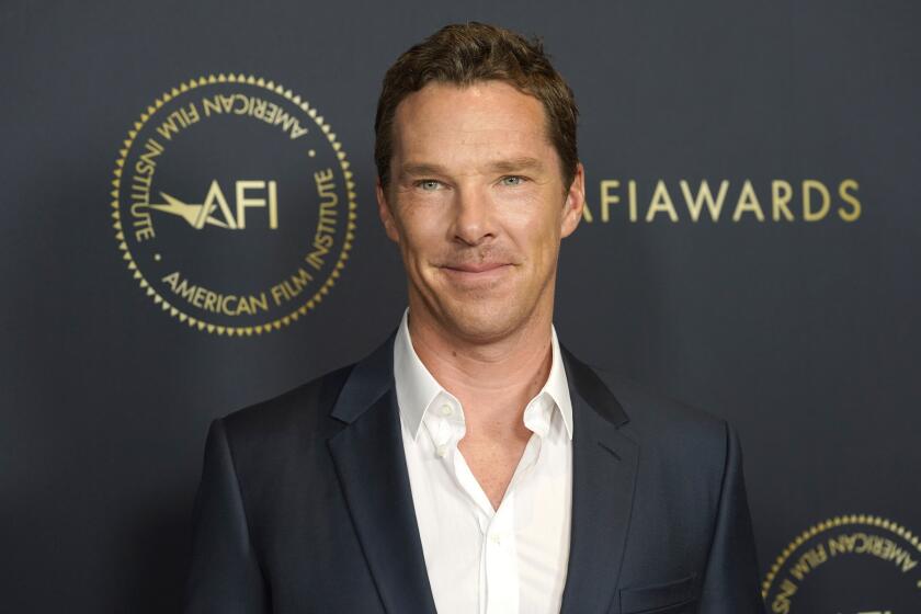 Benedict Cumberbatch posing in a gray suit and white shirt