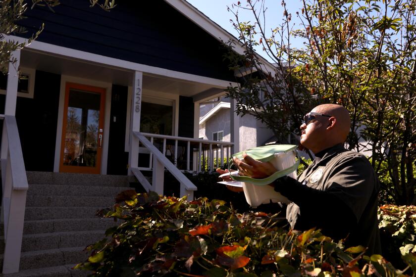 LOS ANGELES, CA - AUGUST 6, 2022 - - LA Sanitation worker Zac Ortiz prepares to deliver an in-home compost pail to a resident in Los Feliz on August 6, 2022. 2022 is the year that most residents of Los Angeles are being instructed to dump their kitchen waste into their green organic waste bin. Previously leftover food went into the regular/landfill (brown) trash can. This shift represents the biggest change in solid waste management in decades. The new program comes under a state law that requires cities and counties to change the way they handle leftover food and kitchen waste. The change is designed to help improve soil health and to reduce methane and other greenhouse gases that form when organic waste goes to a regular landfill. (Genaro Molina / Los Angeles Times)